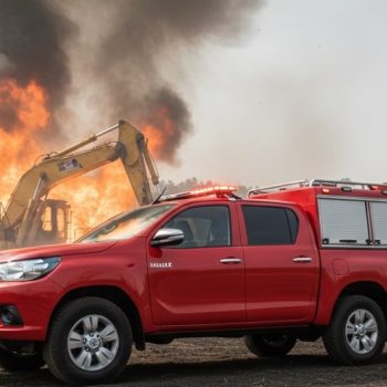 Camioneta autobomba con fuego detrás